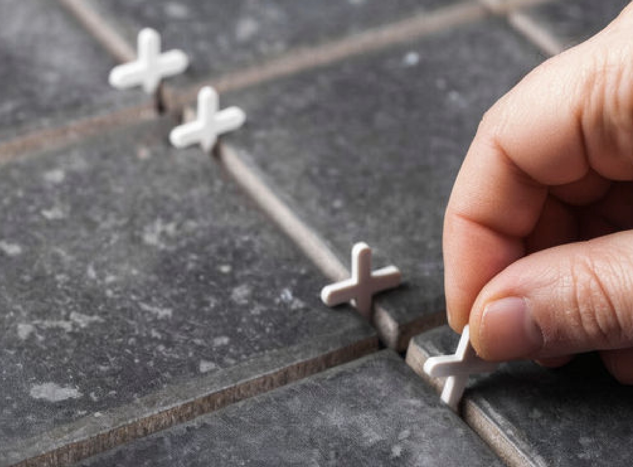 hand placing spacer in tiles
